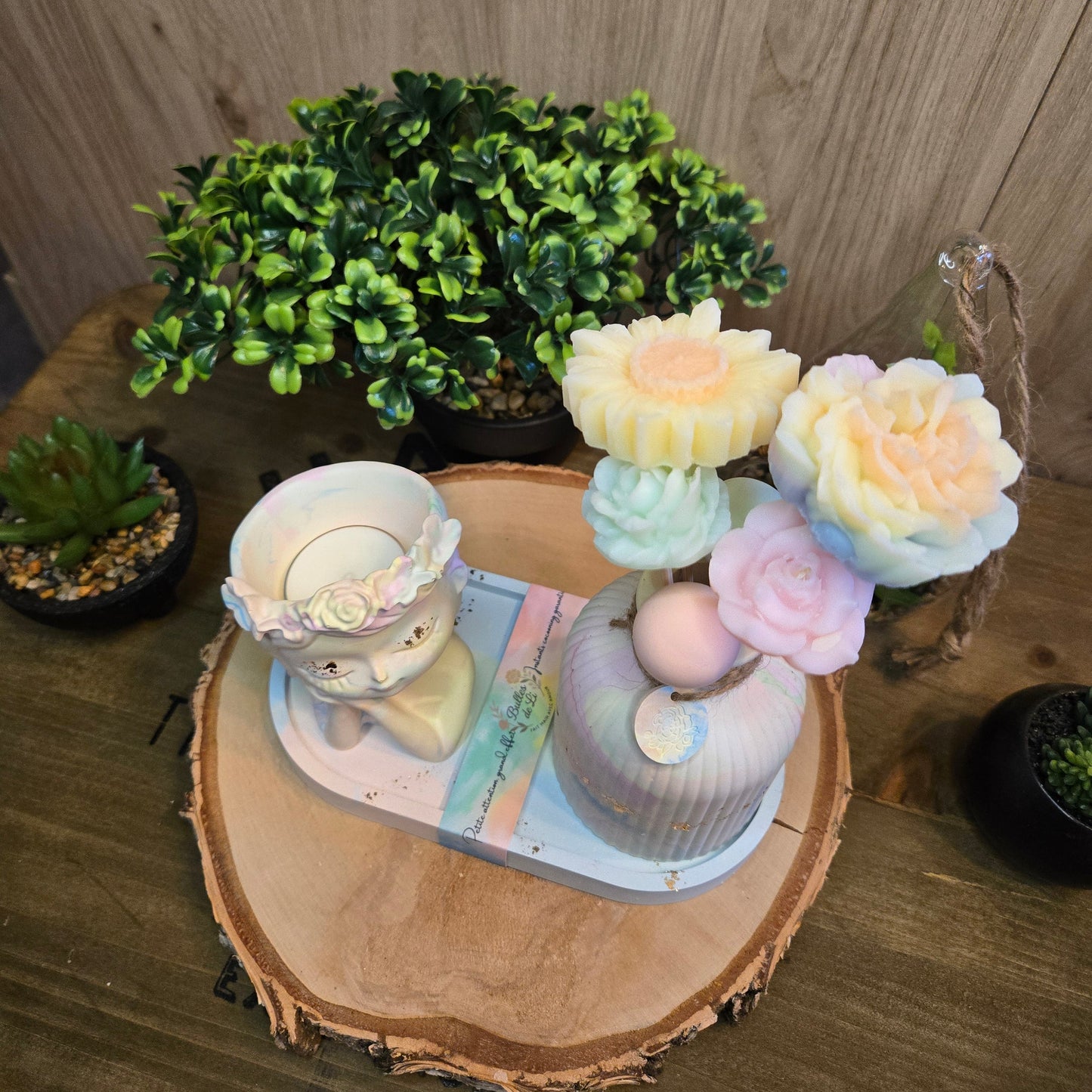 Fleurs fondants parfumés pastel en cire végétale avec détails délicats, présentées dans un vase en plâtre artisanal.
