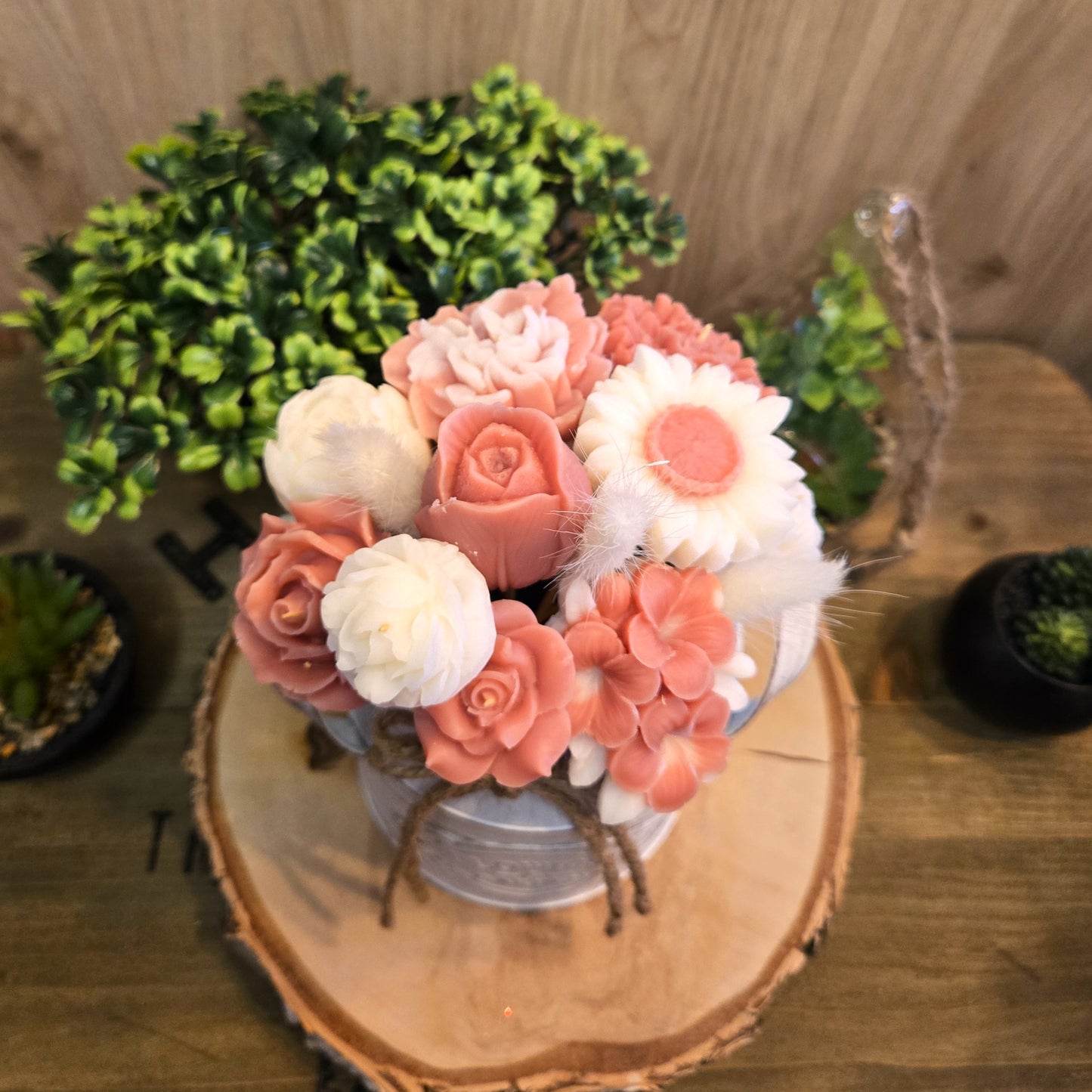 Bouquet en cire coco parfumée dans un vase décoratif, vu du dessus avec détails des fleurs moulées main.