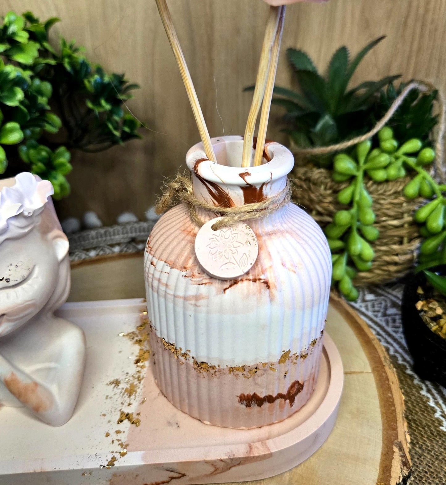 Gros plan sur le vase marbré contenant les fondants en forme de fleurs – décoration parfumée artisanale