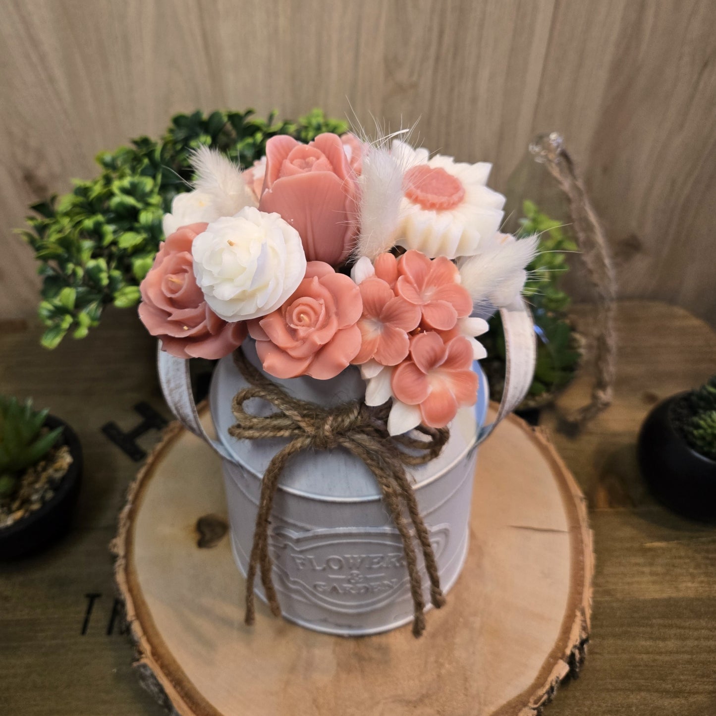 Vue rapprochée du bouquet en cire végétale coco, fleurs artisanales roses et blanches dans leur vase décoratif.

